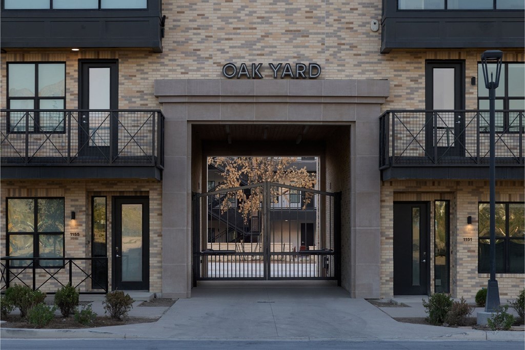 The entrance to a building called Oak Yard with a black gate.