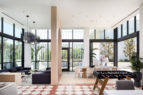A modern living room with a foosball table in the middle.