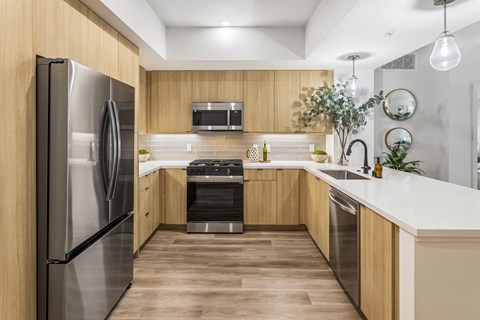 A modern kitchen with wooden cabinets and stainless steel appliances.