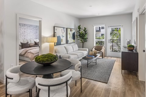 A modern living room with a black table and white chairs.