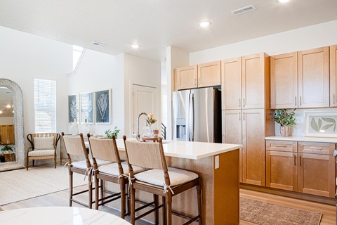 A kitchen with wooden cabinets and a white island.