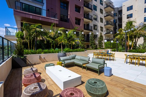 A patio with a white table and chairs and a couch.