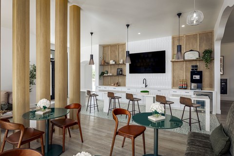 A modern kitchen with a bar area and a dining table set up.