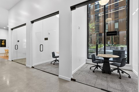 A conference room with a table and chairs is visible through glass doors.