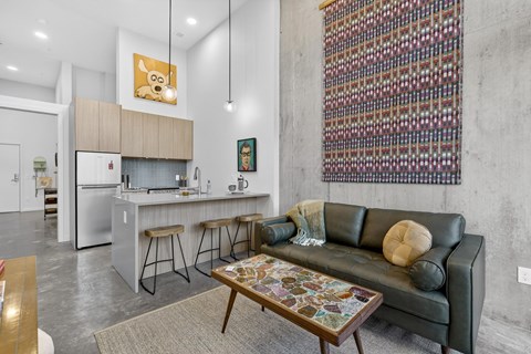A modern kitchen with a bar and a couch.