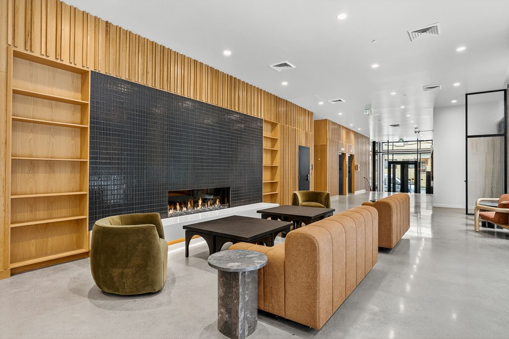 A modern community room with a fireplace and wooden accents.