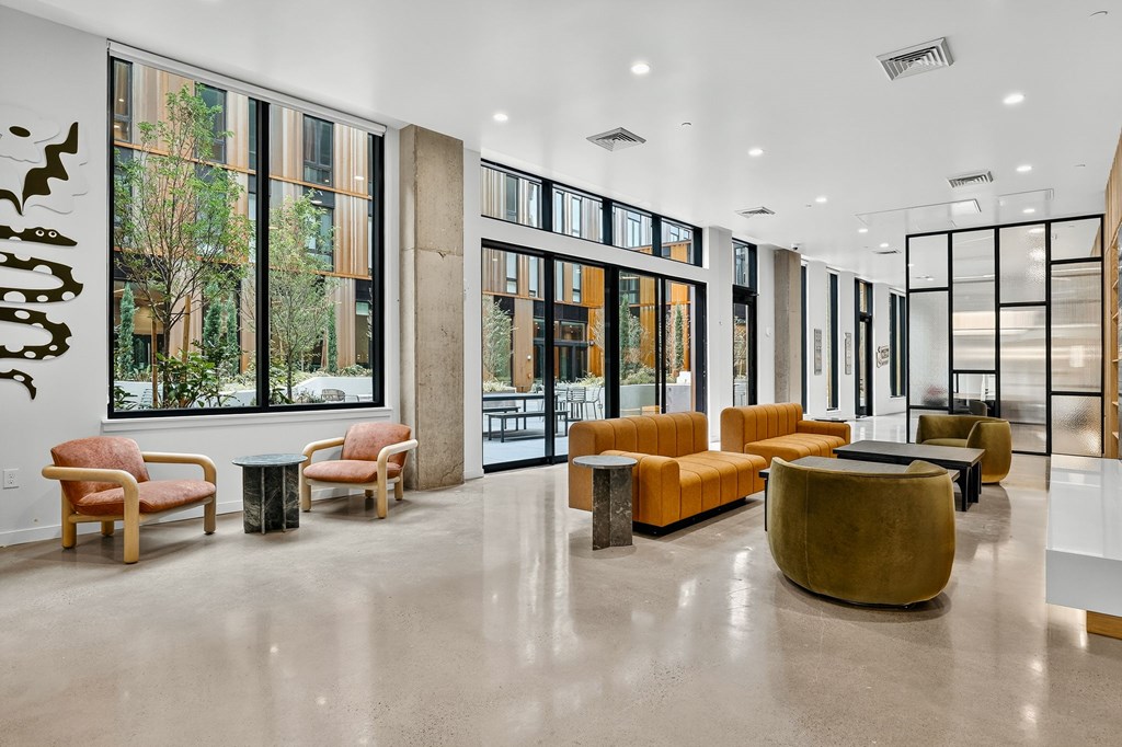A spacious lobby with a large window and a view of trees.