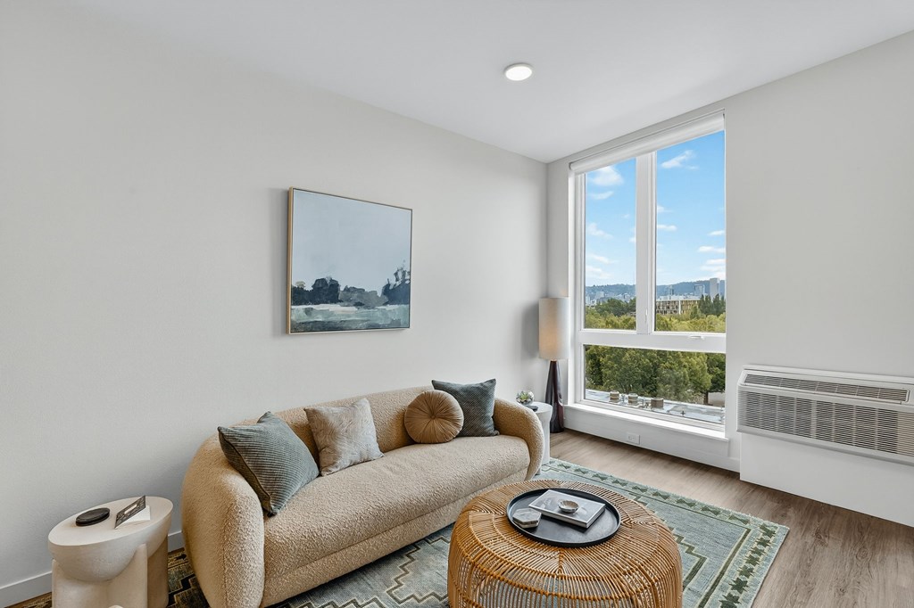 A living room with a couch, a coffee table, and a painting on the wall.