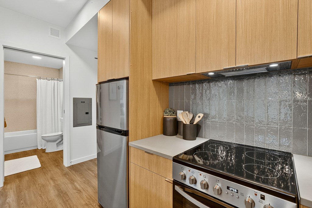 A kitchen with a stove top oven and a refrigerator.