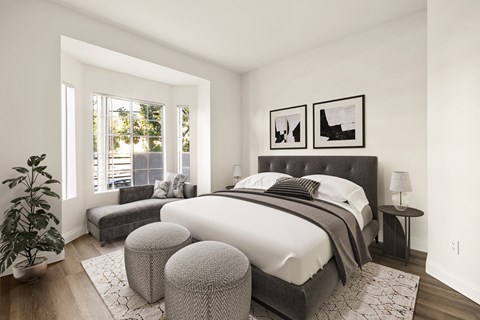 A bedroom with a large bed and a potted plant.
