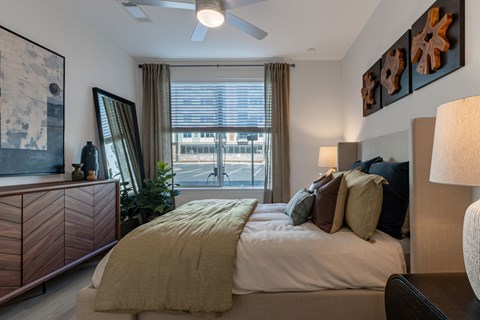 A bedroom with a large bed and a ceiling fan.