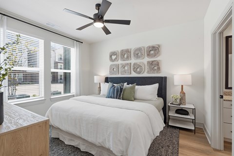 A bedroom with a large bed and a ceiling fan.