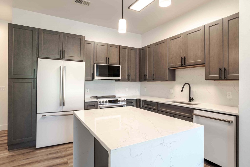 a kitchen with a large island and stainless steel appliances