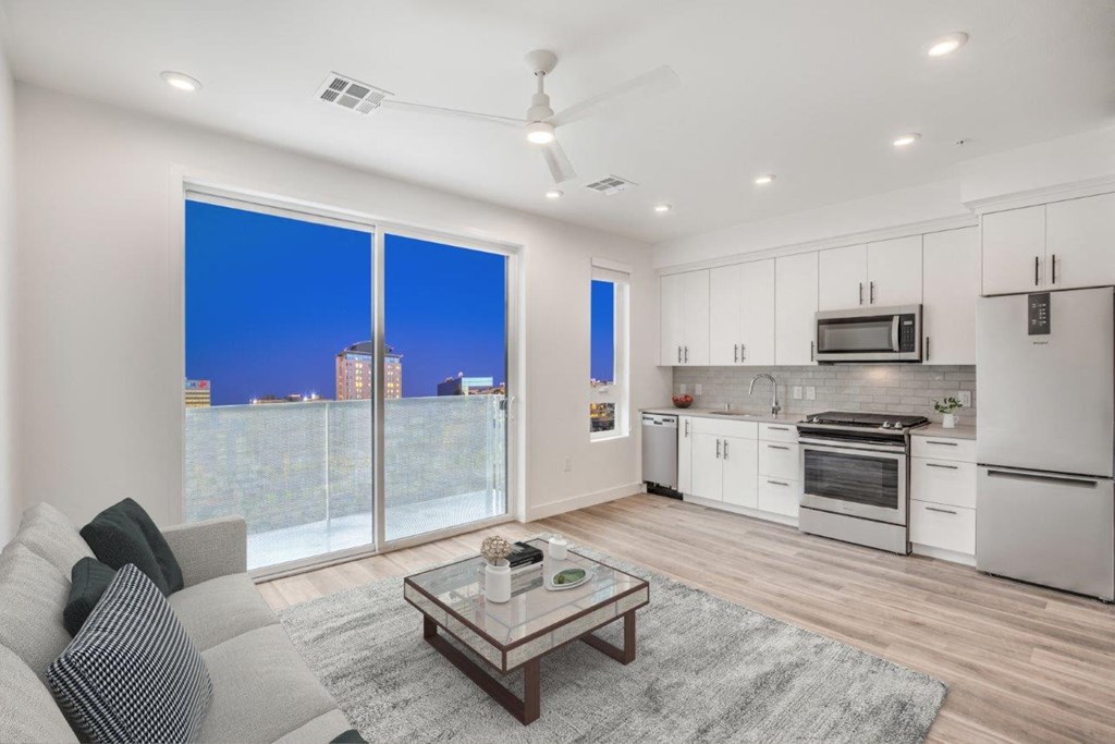 a living area with a couch coffee table and a window with a view