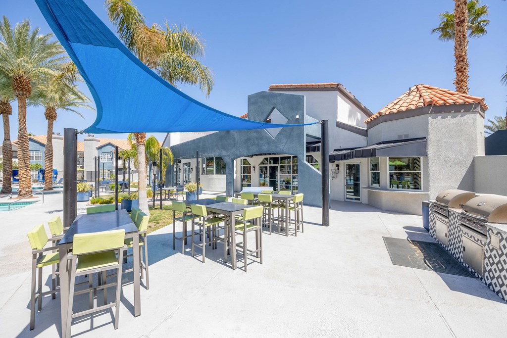 a patio with tables and chairs and a building in the background