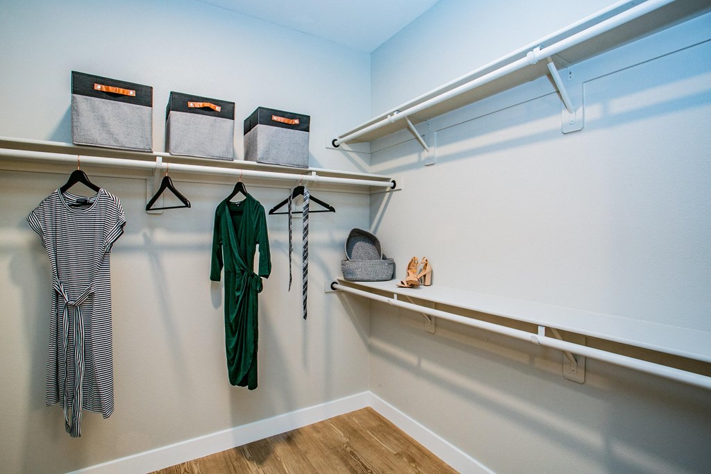 a walk in closet with shelves and a shelf with bags on it