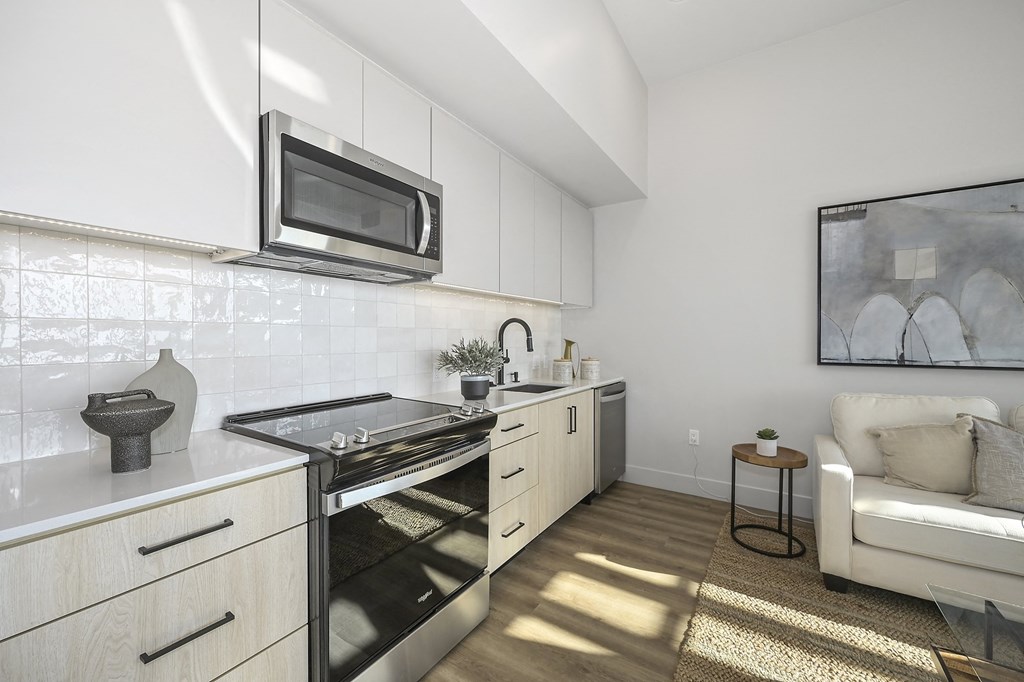 a kitchen with white cabinets and a stove and microwave