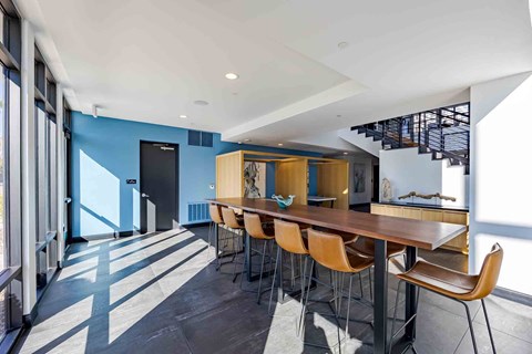 A modern dining room with a long table and chairs.