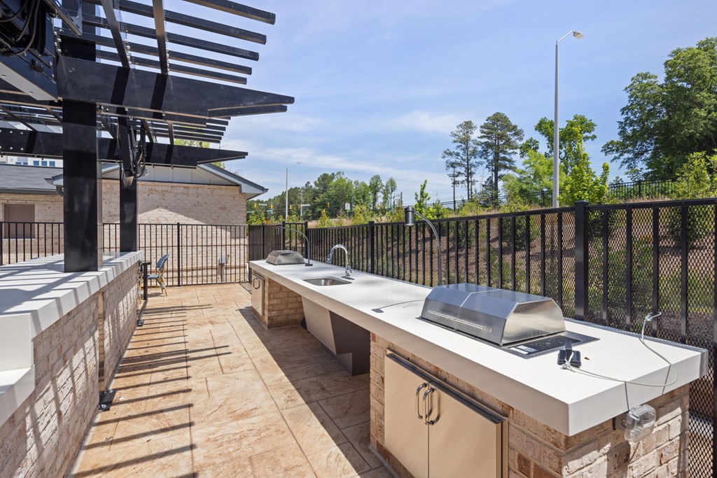 A patio with a grill and a table.