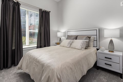 A bedroom with a large bed and two nightstands