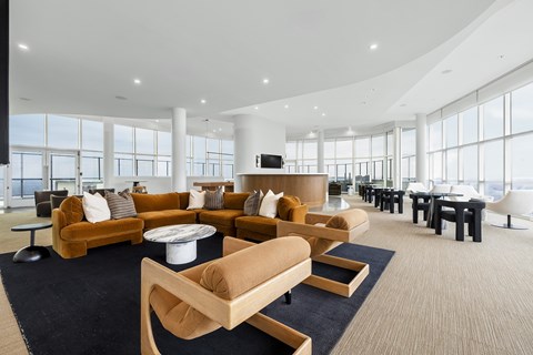 A modern living room with a large sofa set and a television.