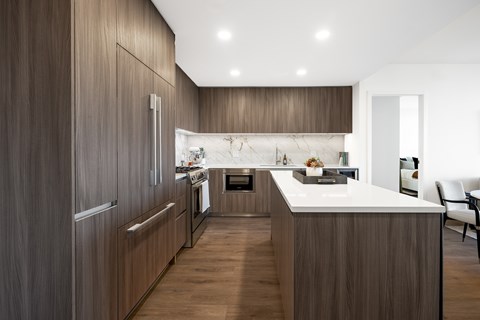 A modern kitchen with dark wood cabinets and a white countertop.