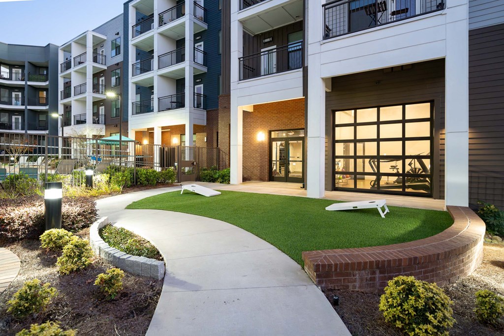 an image of an apartment building with a yard and grass