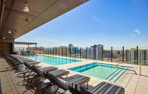 a pool on the top of a building with a view of the city