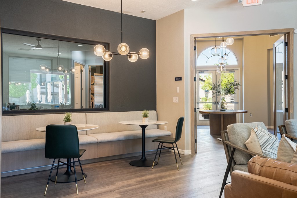 a living room with tables and chairs and a large mirror