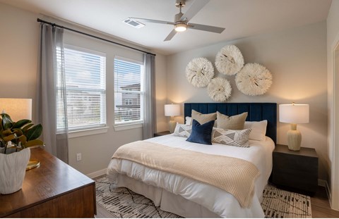 a bedroom with a large bed and a ceiling fan
