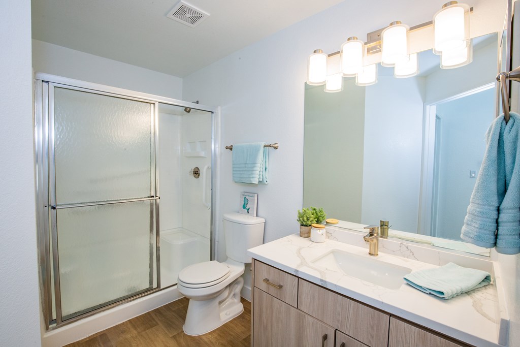 A bathroom with a toilet, sink, and shower.