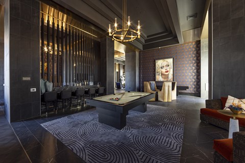 A room with a pool table and a bar area.