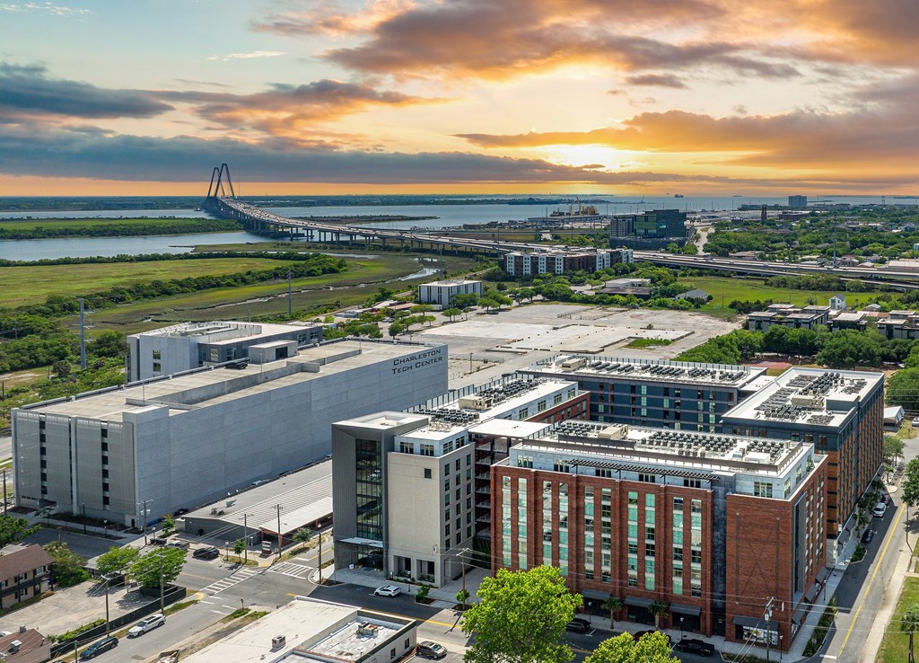 A cityscape with a bridge in the background and a building with a red brick facade in the foreground.