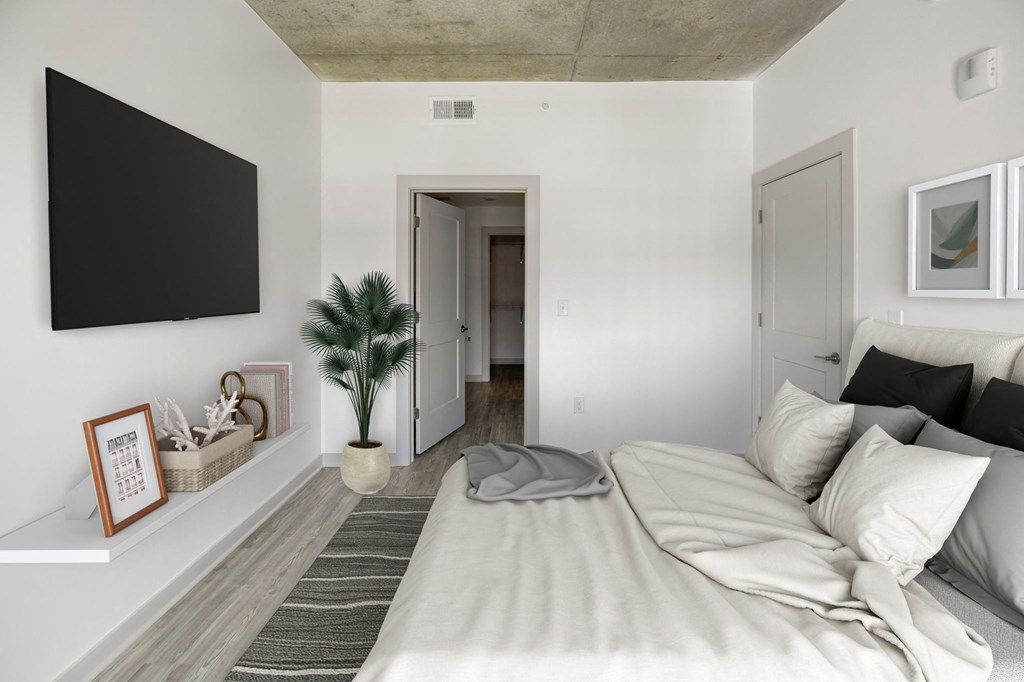 a bedroom with a large bed and a tv on the wall