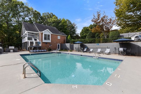 A large swimming pool with a house in the background.