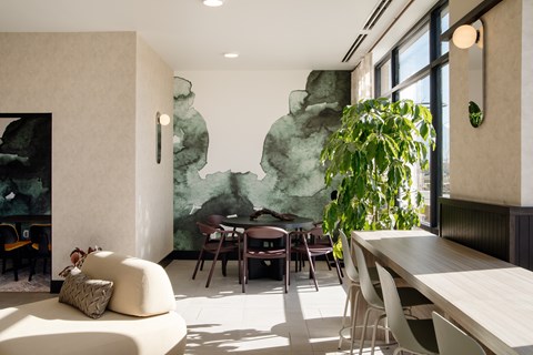 A modern dining room with a large green painting on the wall.