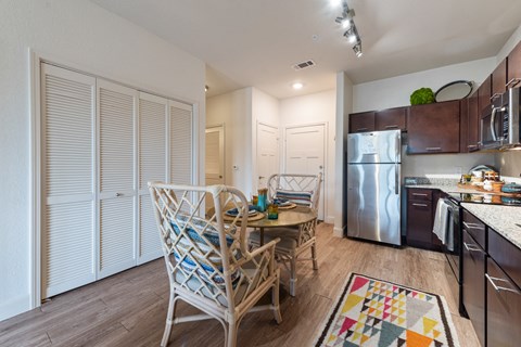a dining room and kitchen with a table and chairs and a refrigerator