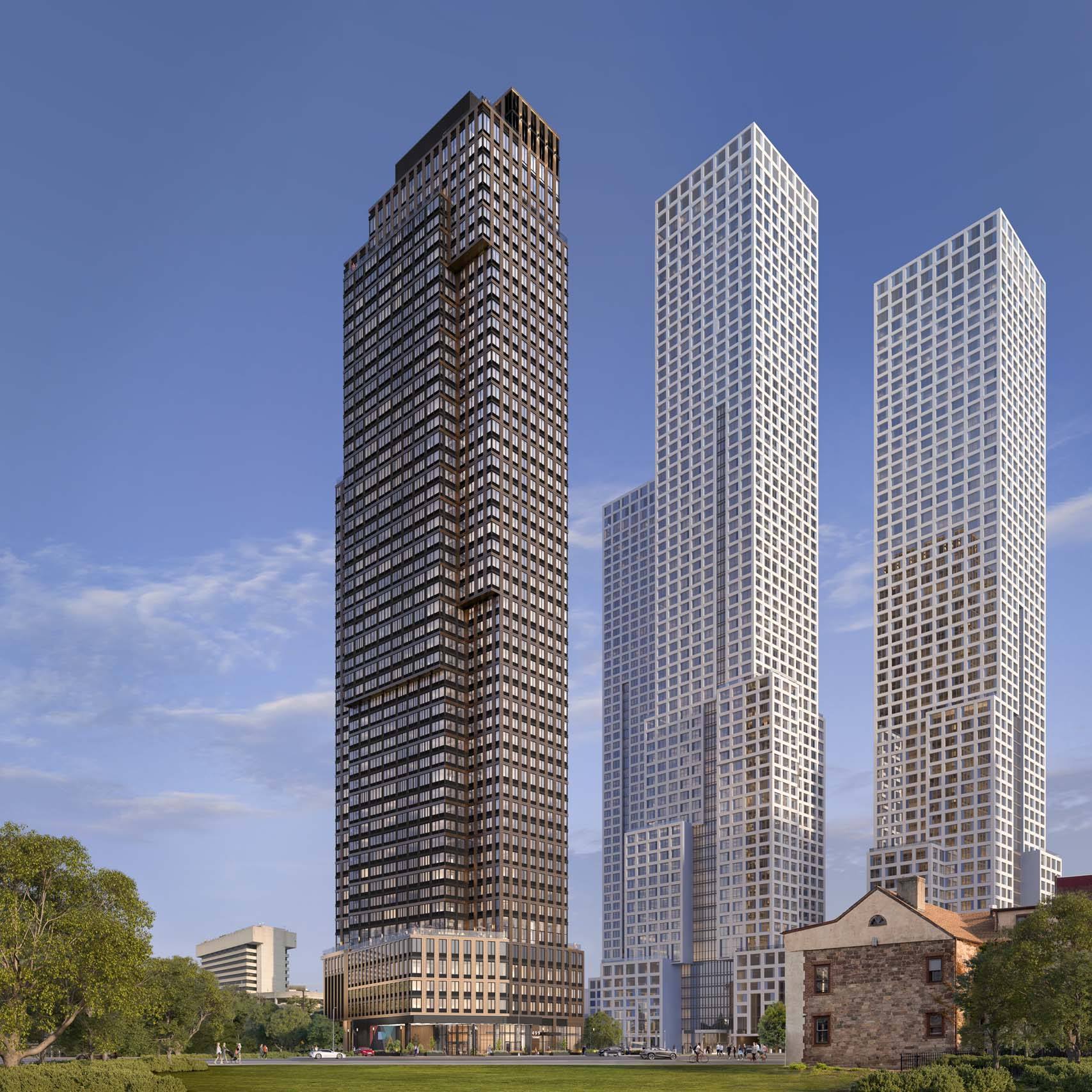 Three tall buildings stand in a row with a grassy area in the foreground.