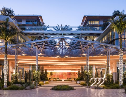 A modern building with a large glass entrance and a canopy over it.