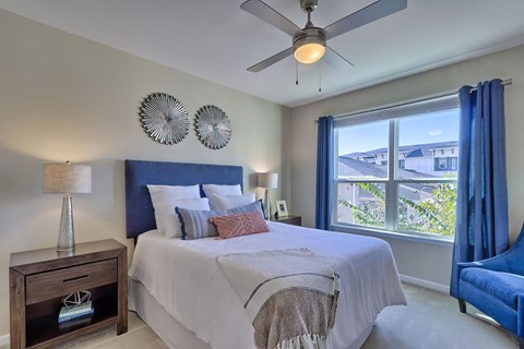 a bedroom with a bed and a ceiling fan