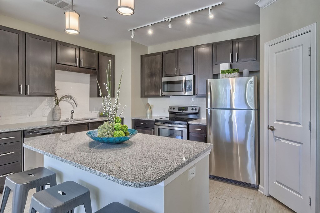 a kitchen with a granite counter top and stainless steel refrigerator