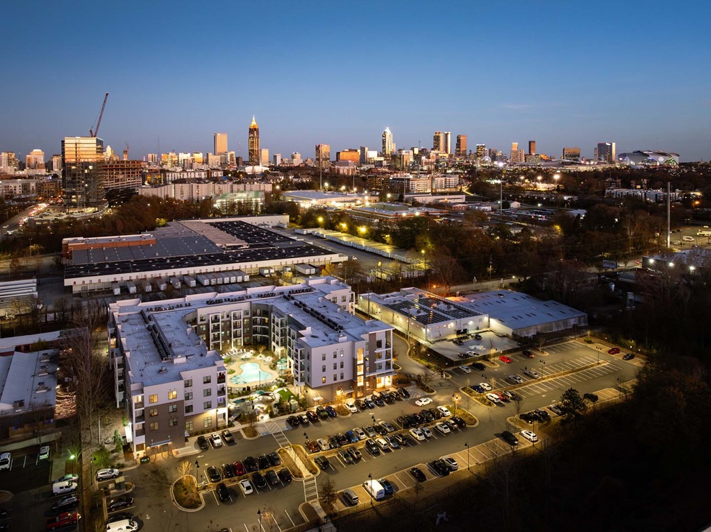 the campus at night with the city skyline in the background