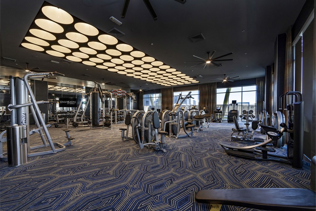 A gym with a variety of equipment including treadmills, weights, and exercise machines.
