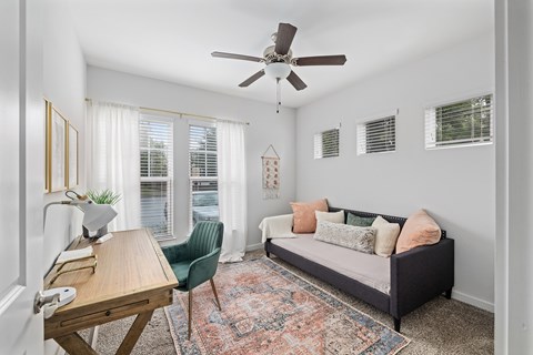 A living room with a sofa, a chair, a table, and a rug.