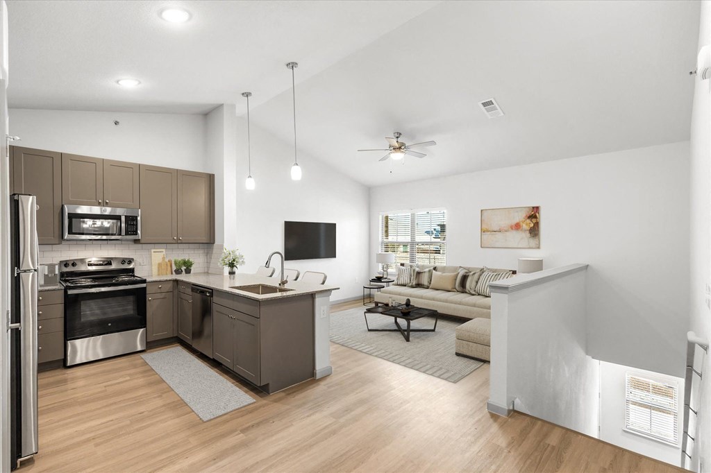a kitchen and living room with white walls and hardwood floors