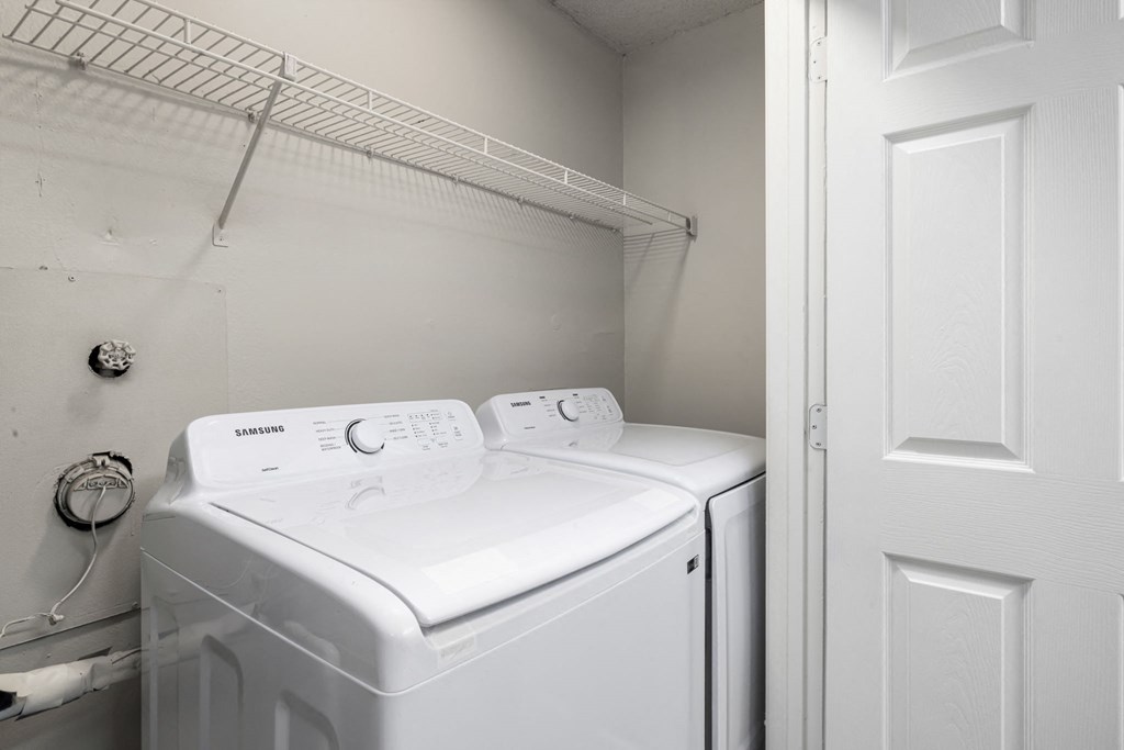 a white washer and dryer in a laundry room with a white door