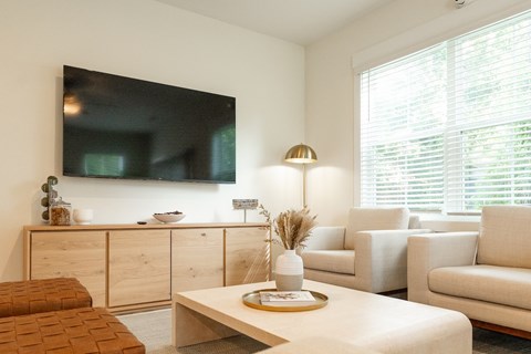 A living room with a flat screen TV mounted on the wall.