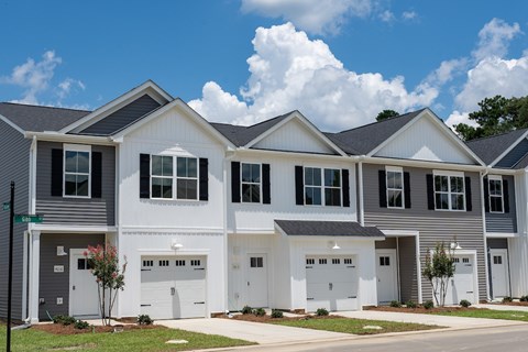 A row of houses with garages and driveways.