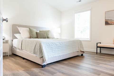 A bedroom with a large bed and a bench.