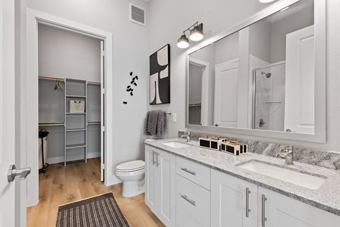 A bathroom with a toilet, sink, and mirror.